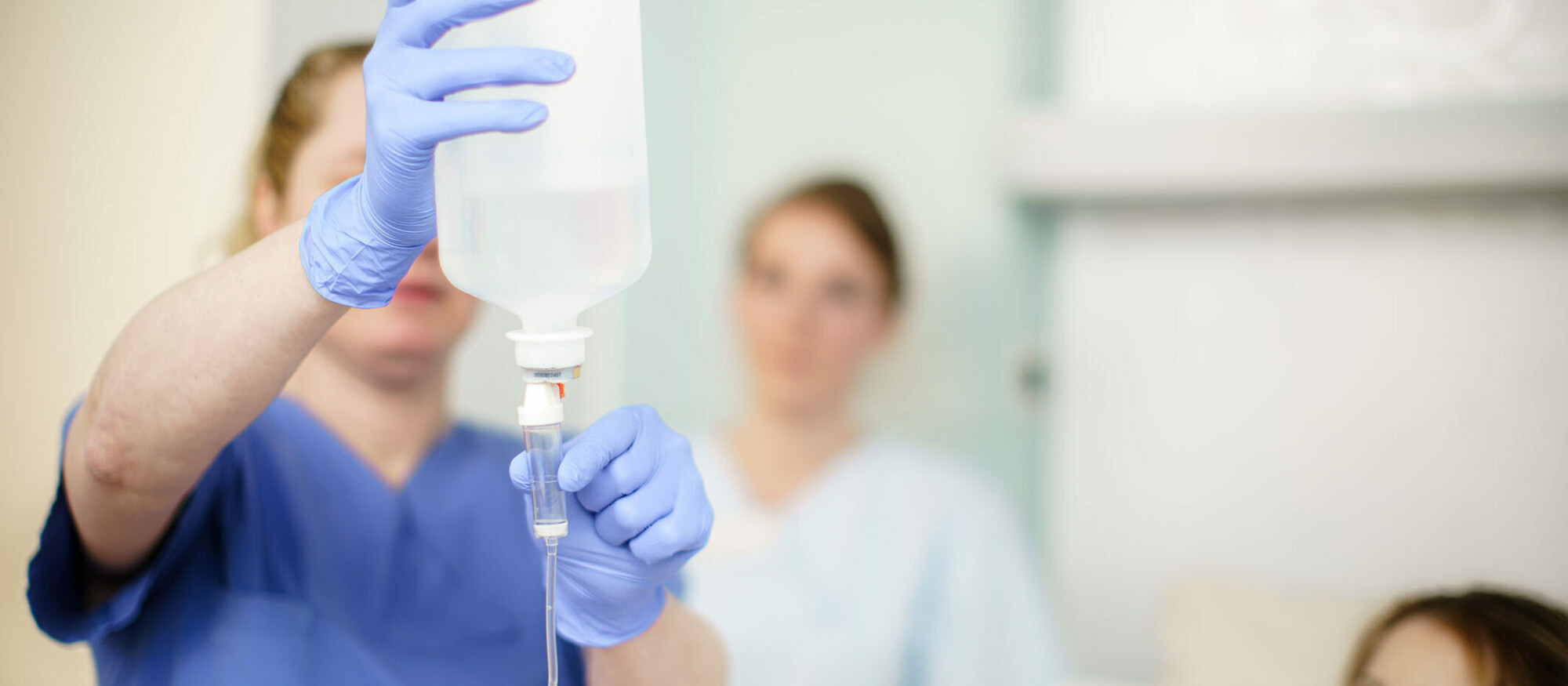 Pflegerin bereitet Infusion für Patientin vor