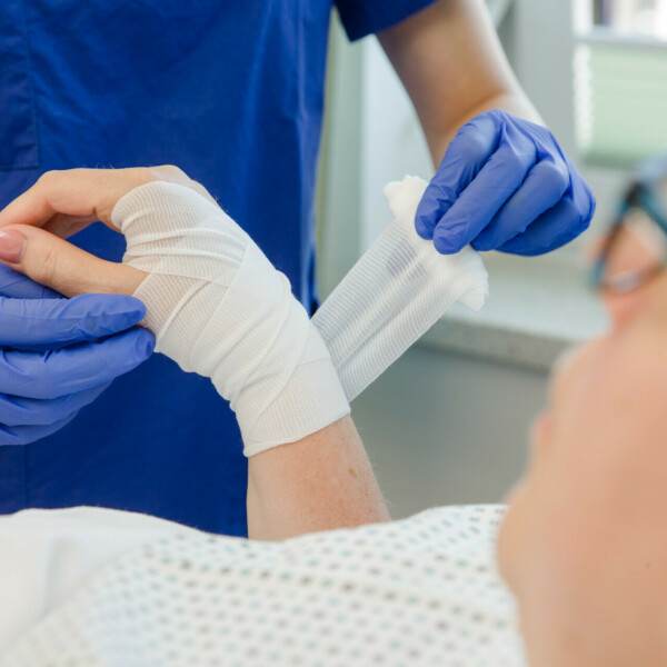 Patienten wird an Hand mit Verband gebunden