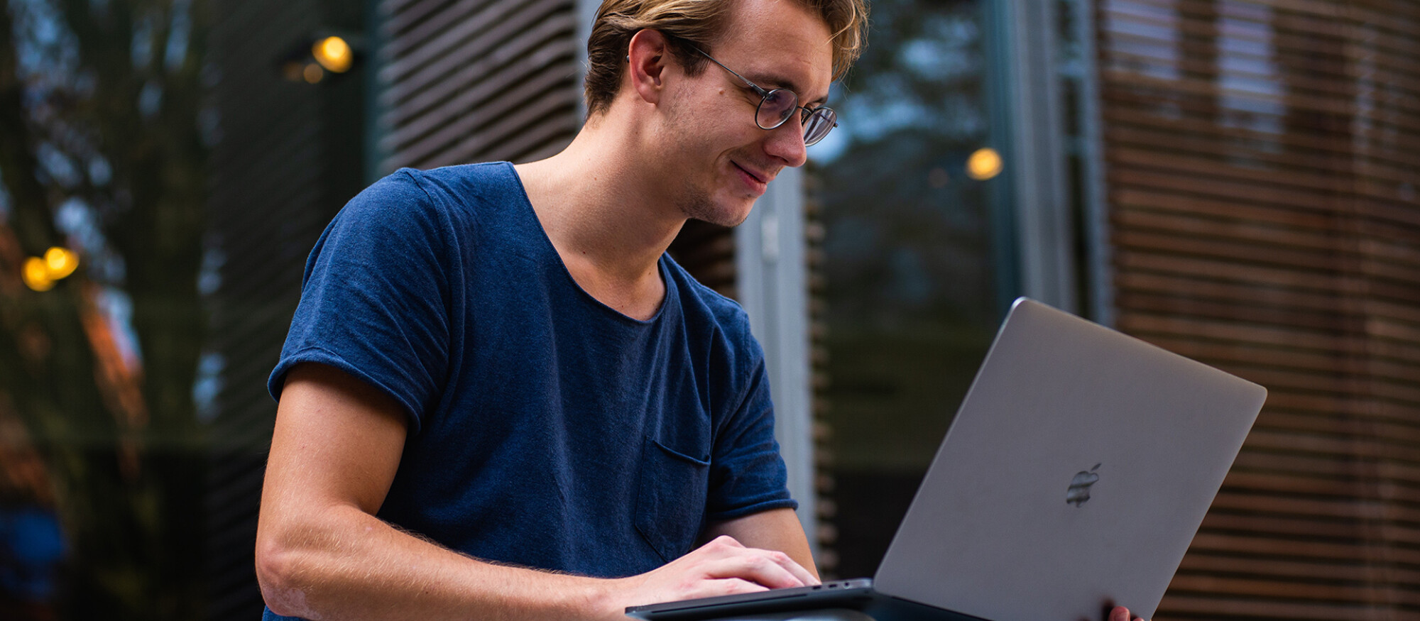 Junger Mann mit Laptop auf Schoß