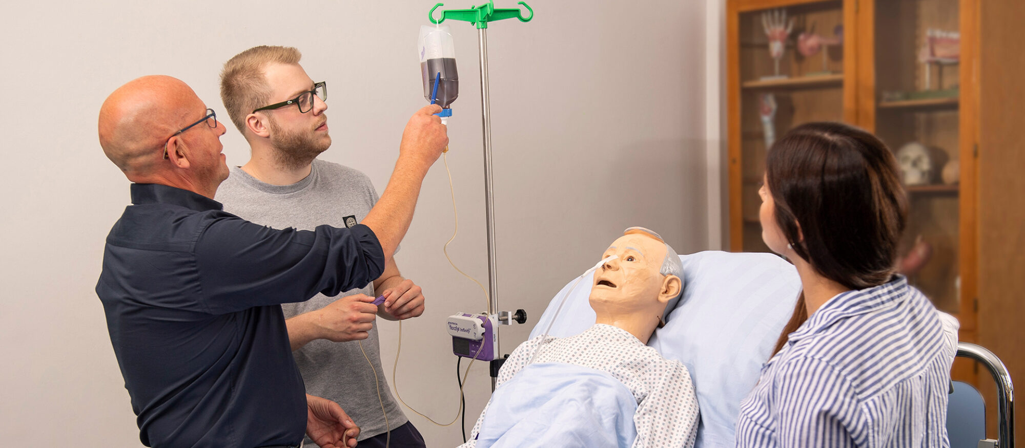 Ausbilder zeigt Schüler etwas am Krankenbett