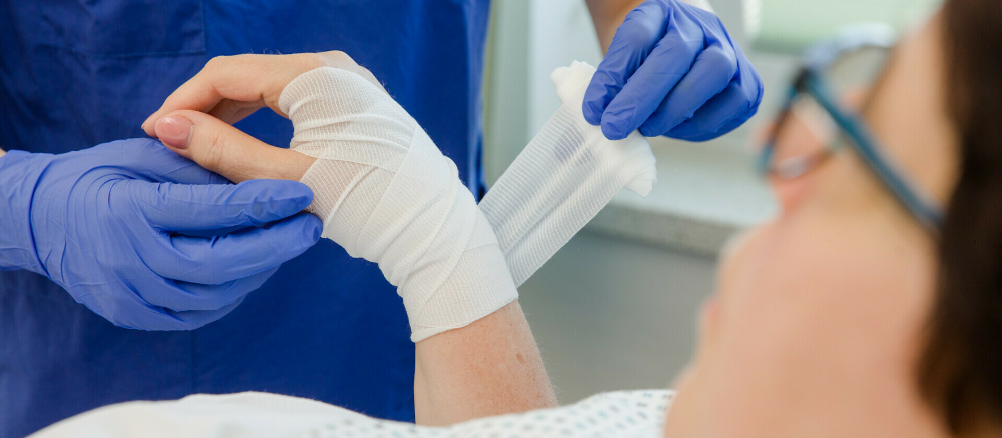 Patienten wird an Hand mit Verband gebunden