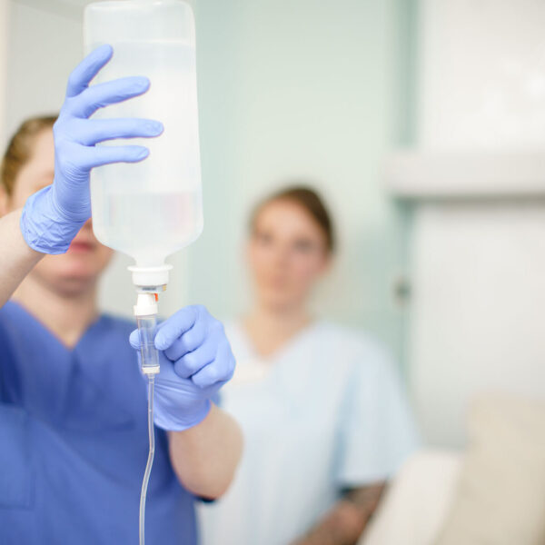 Pflegerin bereitet Infusion für Patientin vor