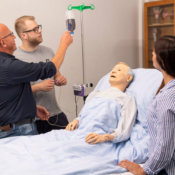Ausbilder zeigt Schüler etwas am Krankenbett